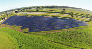 Photo of a large solar array in a green field