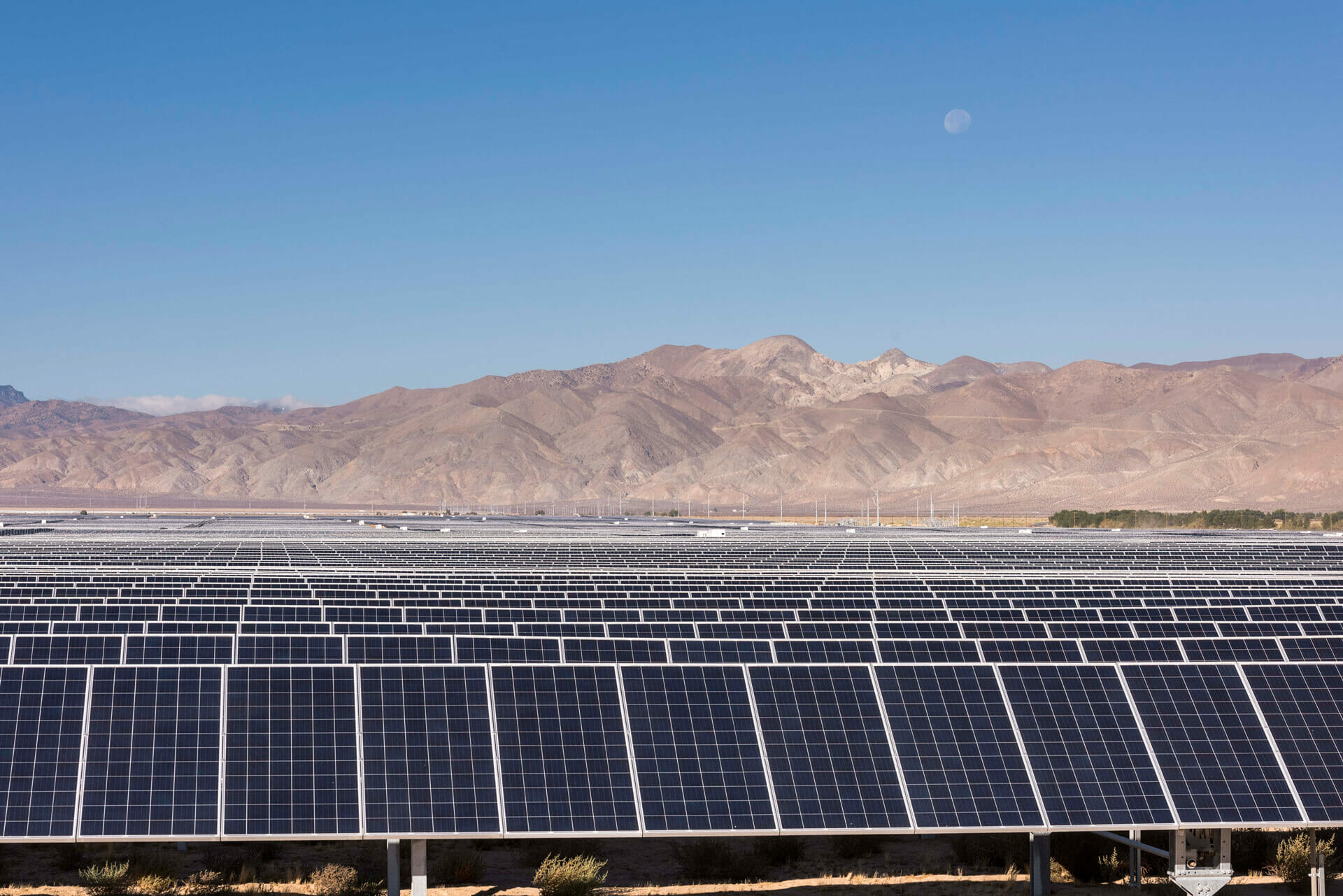 Photo of a large solar plant in front of mountains