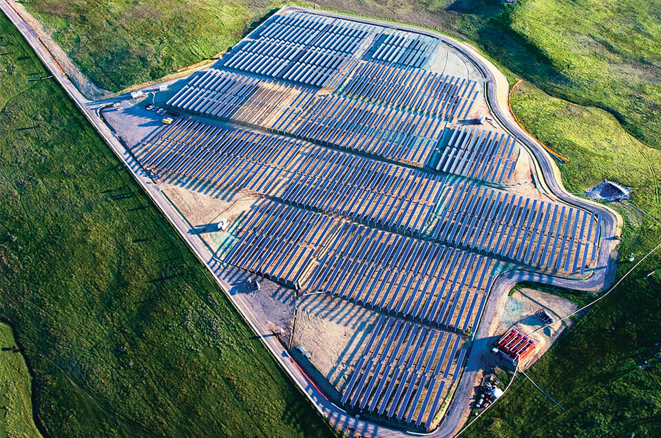 Aerial photo of a solar farm on green hills