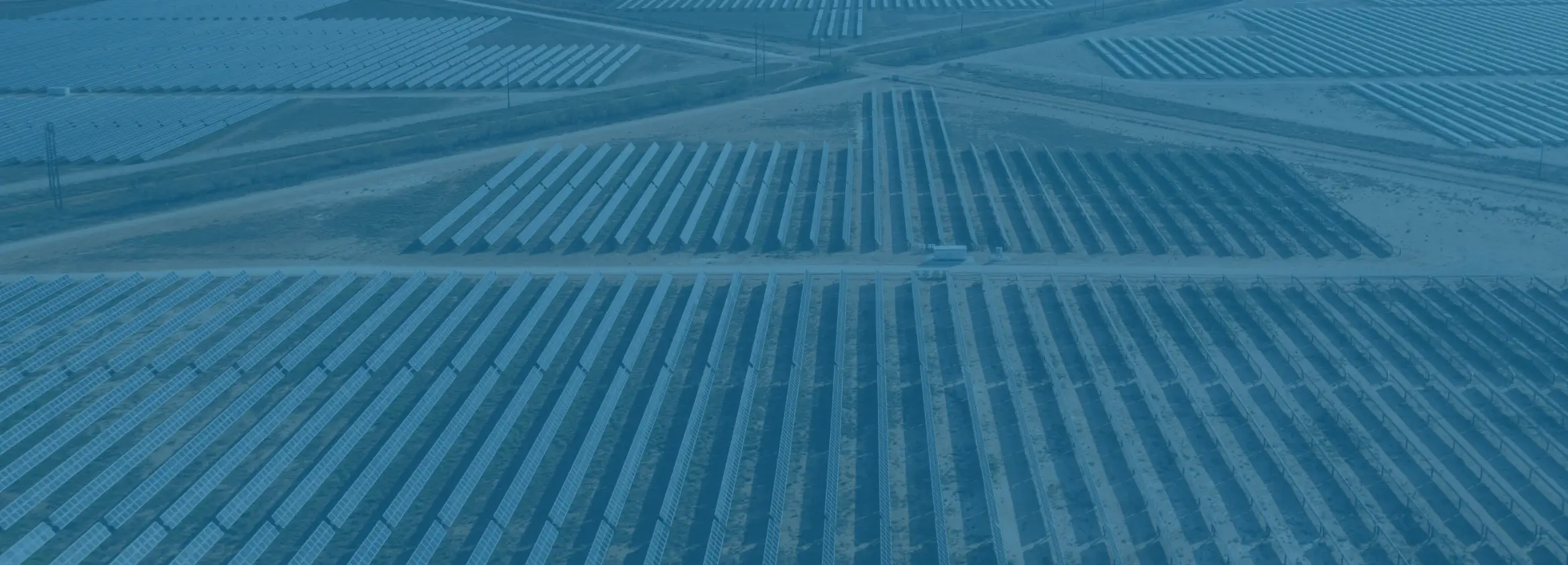 blue-tinted image of solar panel fields